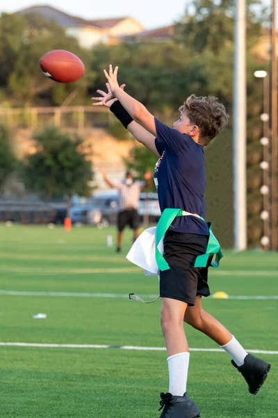 Genç atletik çocuk bayrak futbolunda oynuyor.