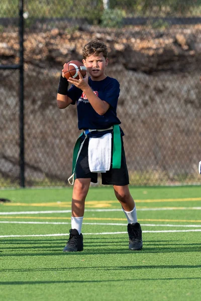 Genç atletik çocuk bayrak futbolunda oynuyor.