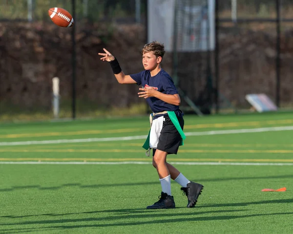 Genç atletik çocuk bayrak futbolunda oynuyor.