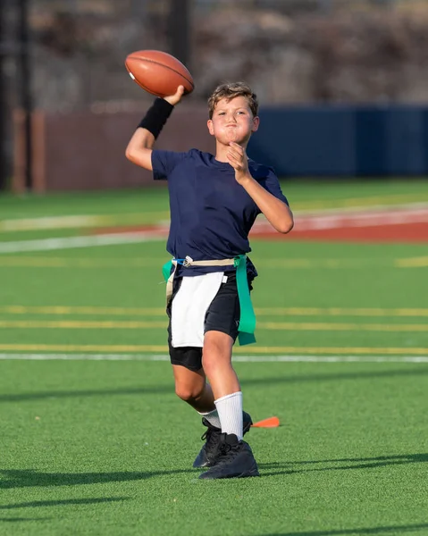 Genç atletik çocuk bayrak futbolunda oynuyor.