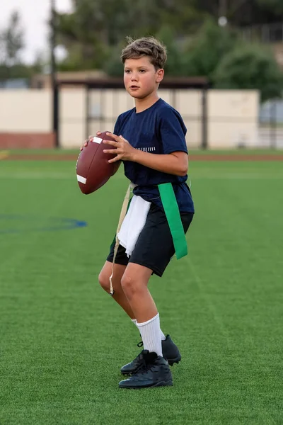 Genç atletik çocuk bayrak futbolunda oynuyor.