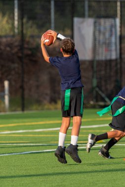 Genç atletik çocuk bayrak futbolunda oynuyor.