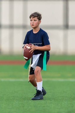 Genç atletik çocuk bayrak futbolunda oynuyor.