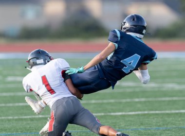 İnanılmaz sporcular, rekabetçi bir futbol maçında harika yakalayıp koşuyor.