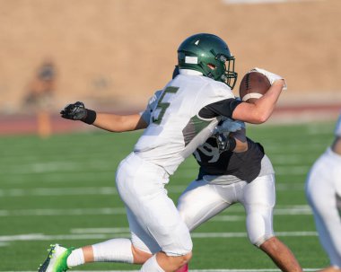 İnanılmaz sporcular, rekabetçi bir futbol maçında harika yakalayıp koşuyor.