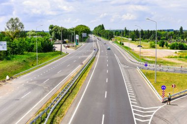 Poltava, Ukrayna - 24 Temmuz 2020: Araba mavi gökyüzünün arka planında asfalt ile yeni bir otoyolda ilerliyor