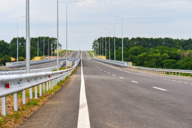 Yazın mavi gökyüzünün arka planında yeni asfalt karayolu