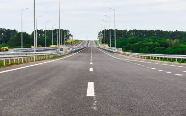 Yazın mavi gökyüzünün arka planında yeni asfalt karayolu