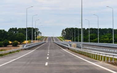 Yazın mavi gökyüzünün arka planında yeni asfalt karayolu