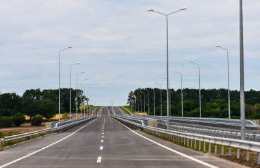 Yazın mavi gökyüzünün arka planında yeni asfalt karayolu