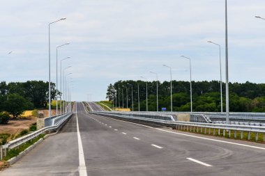 Yazın mavi gökyüzünün arka planında yeni asfalt karayolu