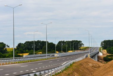 Yazın mavi gökyüzünün arka planında yeni asfalt karayolu