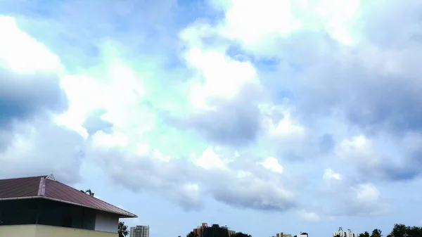 木々の上から遠く離れたところから見ると 雲は暗く 濃い青の色をしています 雲は十分大きく 形も違います — ストック写真