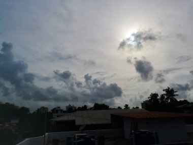 Gün batımında yağmur bulutları etrafını sarar. Bulutlar koyu renklidir ve hindistan cevizi ağaçları gölgesini gökyüzünde oluşturur. Bulutlar yeterince uzundur..