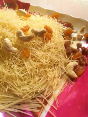 Altın renkli yarı-yeşil ve karışımı kısmi pişirdikten sonra bir tabağa konan fındıklar. Karışımda kaju fıstığı ve kuru üzümlerin yayıldığını görebilirsiniz.