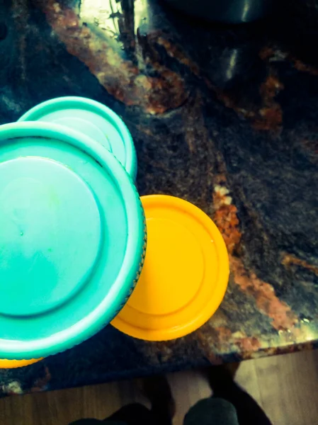 容器にはプラスチック製のキャップがあり キャップの上に円があり 青と黄色の色をしています キャップのグリップが見えます — ストック写真