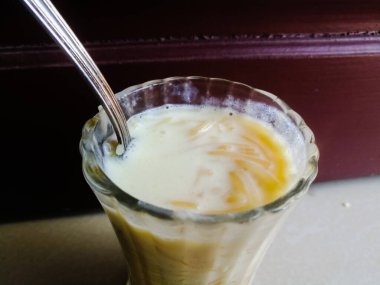 Onam Special Vermicelli payasam in a glass with a spoon with a spoon. Özel çöl veya vermicelli ve beyaz renkli sütten yapılmış tatlı. Bardakta kaşık var..