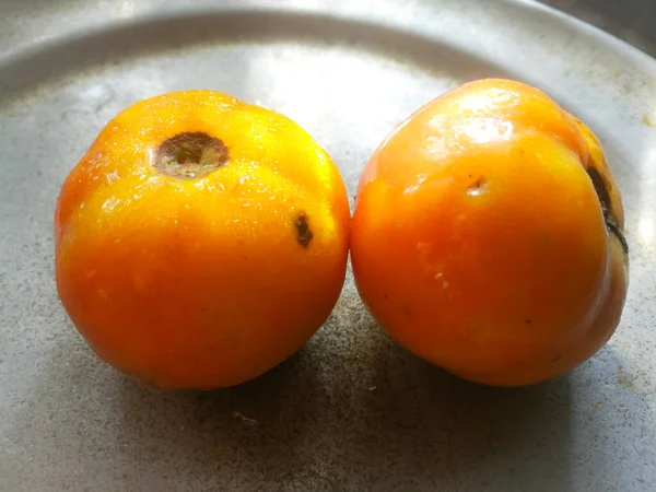 成熟的西红柿放在铝制的板子上 西红柿顶部有一个黑斑 一个是直的 一个是与第一个有角度的 — 图库照片