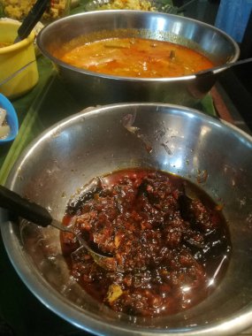 Bir kap dolusu sebze ve baharatın içinde onam özel yemekleri. Yemekler farklı renklerde ve yeşil renkli sebzeler ve soğuk toz nedeniyle kırmızı renkte. Tüm sebzeler.