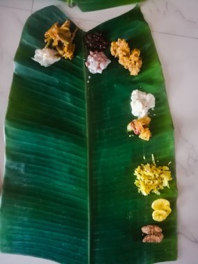 Kerala stilinde Onam Sadhya 'nın üst açı görüntüsü muz yaprağında köri ile. Yaprak pirinçle boş ve kısmen farklı yemeklerle dolu. Muz yaprağının yeşil rengi koyu renklidir..