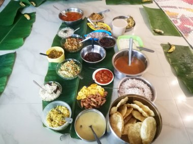 Onam, sebzelerle ayrı kaplarda yapılan özel yemekler. Her yemeğin farklı renkleri var ve yeşil bir muz yaprağına konuyor. Plastik ve çelik kap olarak kullanılıyor..