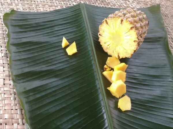 菠萝片放在绿色的香蕉叶中 一个完整的菠萝的横断面是可行的 它的片片放在靠近它的地方 — 图库照片