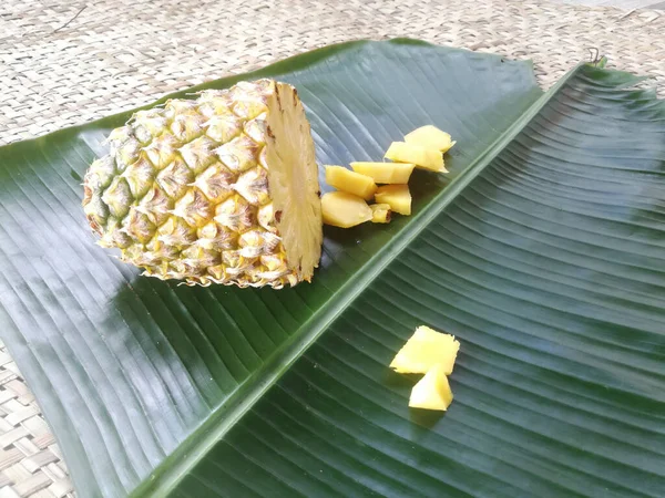 菠萝片放在绿色的香蕉叶中 一个完整的菠萝的横断面是可行的 它的片片放在靠近它的地方 — 图库照片