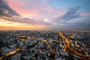 Bangkok, Tayland 'ın hava manzarası, şehirdeki bir gökyüzü barından, gün batımında, şehir ışıkları ve trafik sıkışıklığı ve bulutlu bir gökyüzü..