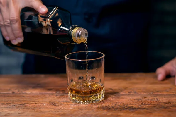 Barman pouring whiskey whiskey glass..