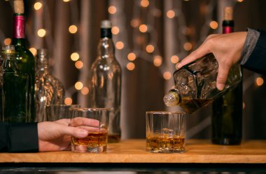 Garson viski bardağı dolduruyor.