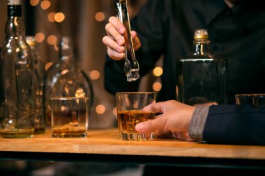 Garson viski bardağı dolduruyor.