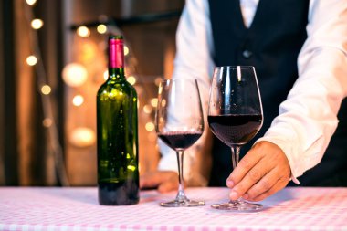 Garson adam bardağa şarap dolduruyor.