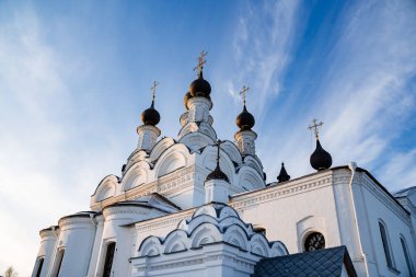 Beyaz, güzel Ortodoks Kilisesi kış zamanı yapım aşamasında. Mavi gökyüzünün karlı manzarası ve altın kubbeleri olan Hristiyan kilisesi.