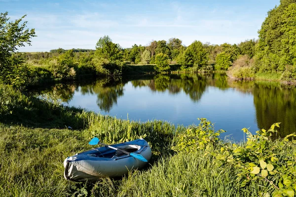 Kayak bleu sur le fond du lac, Journée d'été ensoleillée dans la nature, canoë au bord de l'eau, pagaie, bateau gonflable — Photo