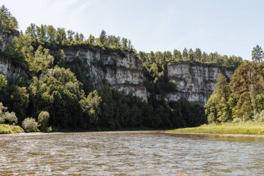 Nehirde yaz günü kayalık kıyılar, mavi gökyüzü, dağlar, orman, manzara, nehir yapay zekası