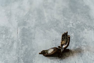 Metal kapı kolları Mudra şeklinde katlanır, gri bir arka planda çekilir, yakın plan, ayrı nesne, yoga teması, bronz ton, Hint motifi