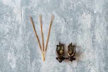Metal kapı kolları Mudra şeklinde katlanmış, gri arka planda çekilmiş, yakın plan, farklı nesne, yoga teması, bronz renk, Hint motifi, tütsü.