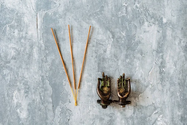 Metal kapı kolları Mudra şeklinde katlanmış, gri arka planda çekilmiş, yakın plan, farklı nesne, yoga teması, bronz renk, Hint motifi, tütsü.