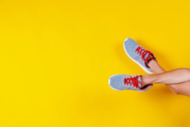 Spor ayakkabıları sarı arka planda, kırmızı bağcıklar, moda blogu ya da dergisi konsepti, minimalist ayakkabı arka planı, spor