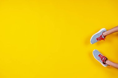 Spor ayakkabıları sarı arka planda, kırmızı bağcıklar, moda blogu ya da dergisi konsepti, minimalist ayakkabı arka planı, spor