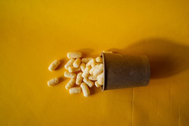 Renkli arka planda bir kutu boya, yeşil, tatlı mısır gölgeleri bir kutu boya, üst görünüm, minimalizm konsepti, sarı arka planda nesne yakın plan