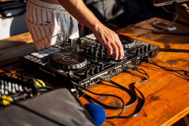 Bir partide DJ uzaktan kumandası, müzik çalmak için renkli düğmeleri olan bulanık arkaplan, yakın plan, yaşam tarzı