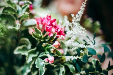 Gelin buketi, düğün buketini elinde tut, saten kurdeleler gül buketini süsle, gelinin elbisesinin arka planında, bir çiçekçi tarafından yapılan taze çiçekler, çiçeklerin kokusu...