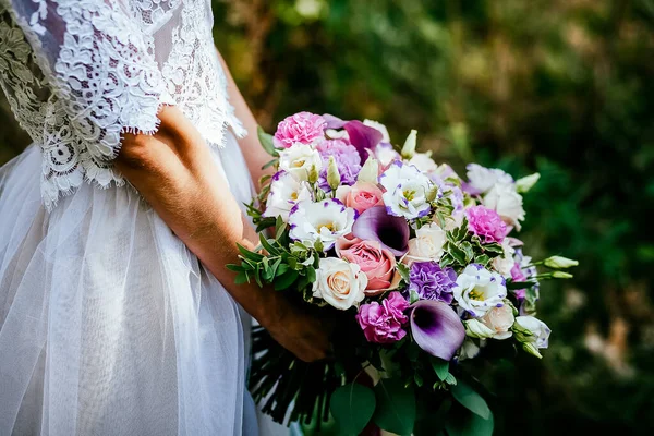 ブライダルブーケ あなたの手で結婚式の花束を保持し サテンリボンは花嫁のドレス 花屋によって作られた新鮮な花 花の香りの背景に バラの結婚式の花束を飾る — ストック写真