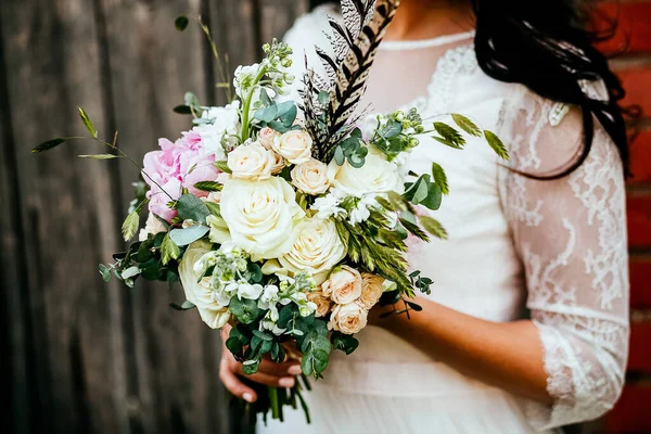 ブライダルブーケ あなたの手で結婚式の花束を保持し サテンリボンは花嫁のドレス 花屋によって作られた新鮮な花 花の香りの背景に バラの結婚式の花束を飾る — ストック写真