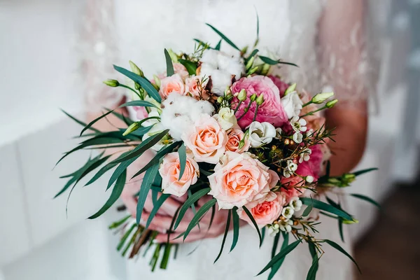 ブライダルブーケ あなたの手で結婚式の花束を保持し サテンリボンは花嫁のドレス 花屋によって作られた新鮮な花 花の香りの背景に バラの結婚式の花束を飾る — ストック写真