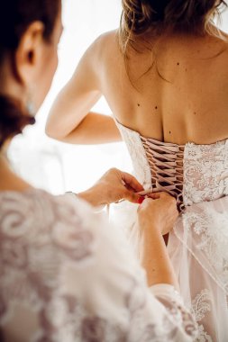 Nedime gelini düğün gününe hazırlar, düğmelerini ilikleyip elbisesini bağlar. Nedime, gelinin gelinliğinin arkasında bir fiyonk yapıyor, gelinin sabah toplantısı.