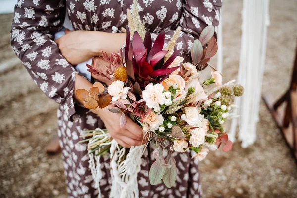花嫁の花束 あなたの手で結婚式の花束を保持し サテンリボンは花嫁のドレス 花屋によって作られた新鮮な花の背景に バラの結婚式の花束を飾る — ストック写真