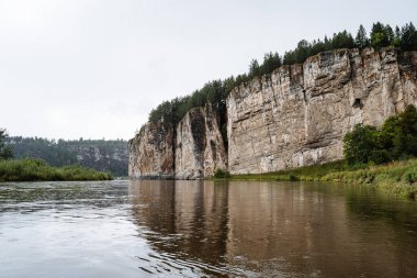Kaya kütlesi, nehir kayalık dağların eteklerinde akar, beyaz taş kayalar, Rusya 'nın doğası, Güney Urallar, Yuryuzan nehri, seyahat fikri.