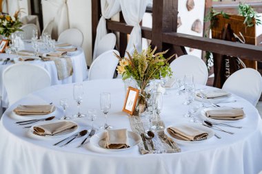 Bayram masası, masaya tabak koymak, beyaz masa örtülü bir ziyafet masası, bayram için yemek masasını hazırlamak, görgü kurallarına göre düzenlenir. Masadaki çiçekler.